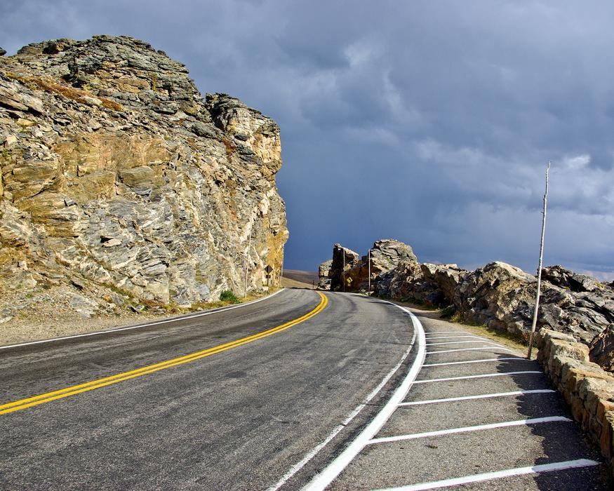 Beautiful road among the rocks, under cloudy sky, in Colorado, USA