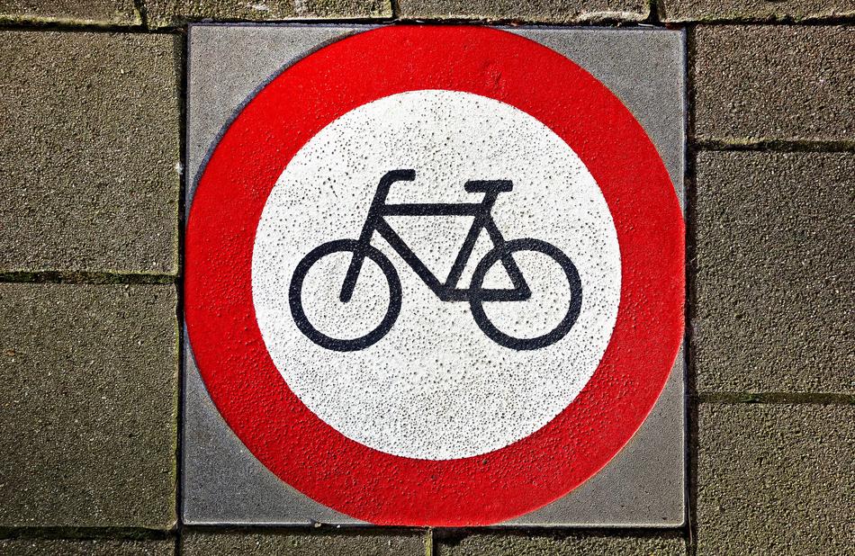 White and red sign with bicycle on the ground in Amsterdam, Netherlands