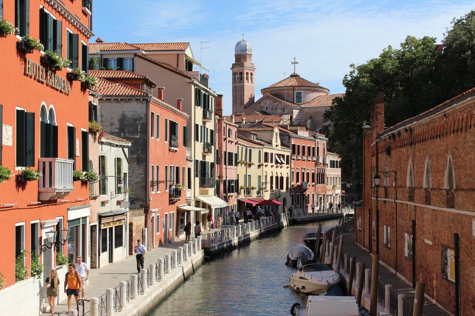 tourists walk along the canal in Venice, Italy