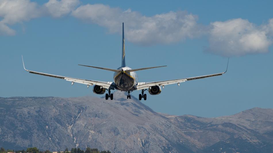 plane in the sky over the island of corfu