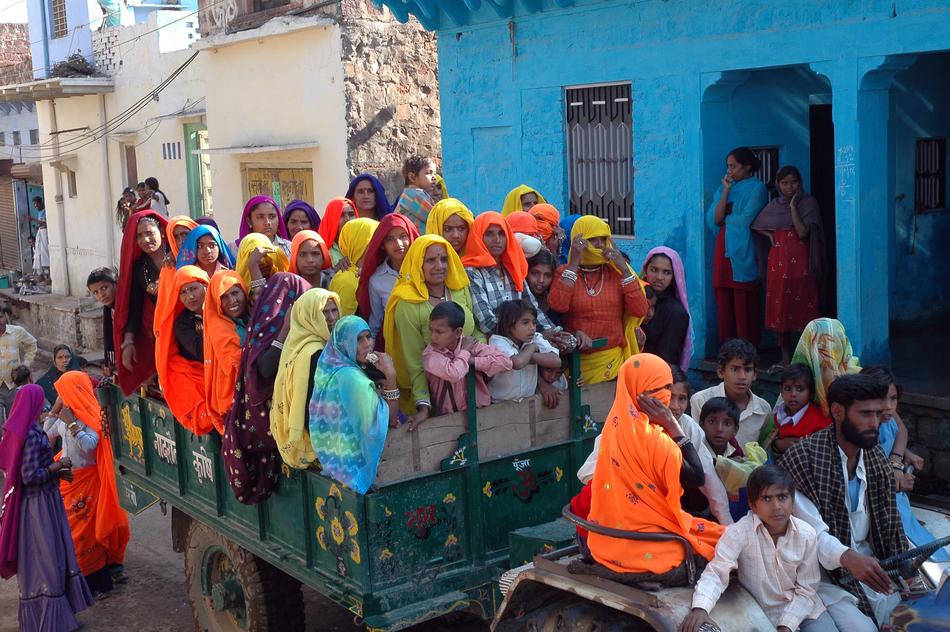 People, on the truck, among the buildings, in India