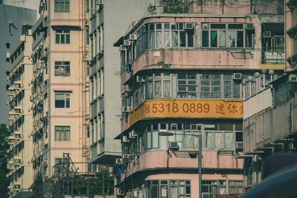 Sign, on the colorful building, among the other buildings in Hong Kong