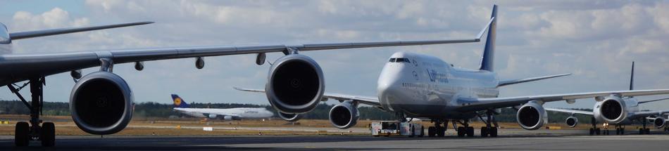 Shiny aircrafts at the airport of Frankfurt, Germany, under the clouds