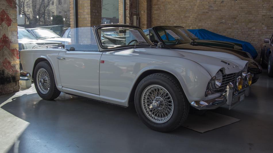 white classic convertible parked near the building
