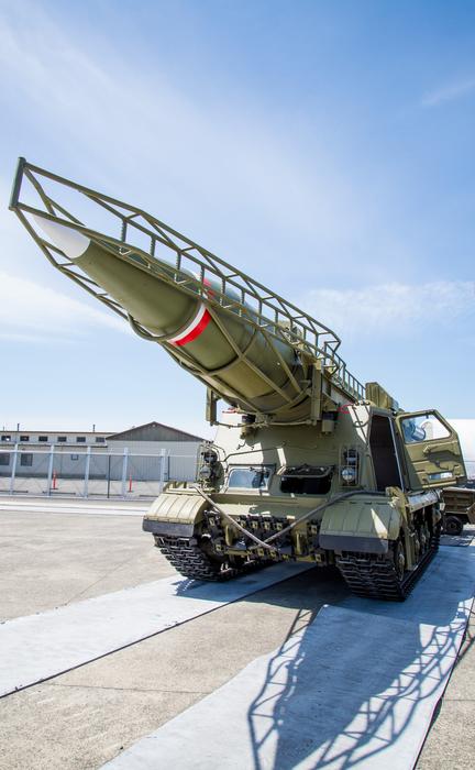 Scud launcher on wheels, in light, at blue sky with white clouds on background