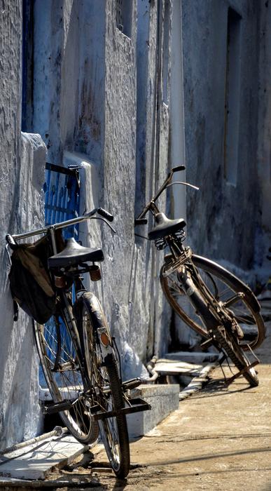 Parked, vintage bicycles, near the wall in light and shadow, in India