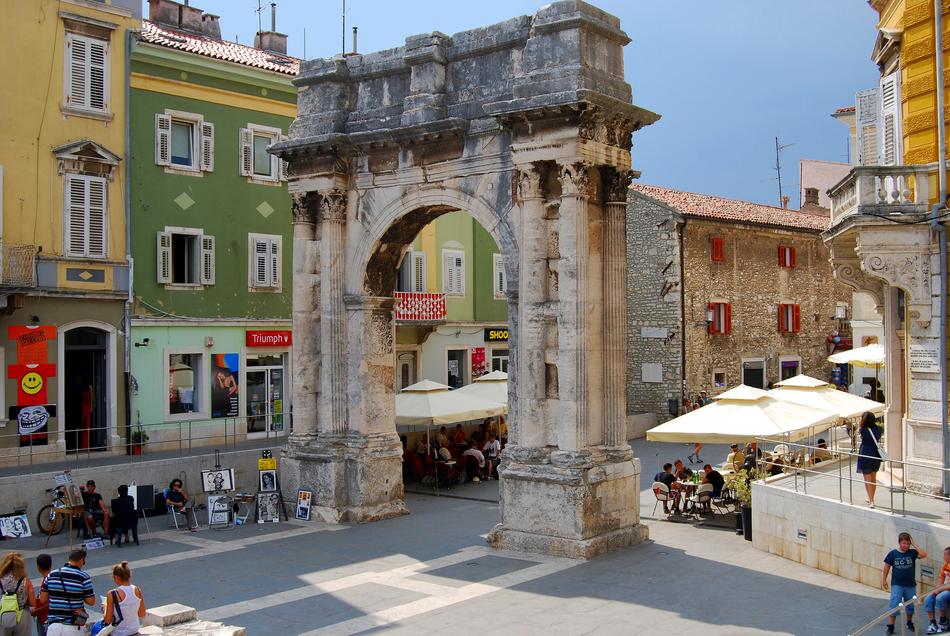 Beautiful street with the colorful houses and Arch Sergius , with people, in Pula, Croatia