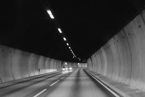 black and white photo of a tunnel with cars