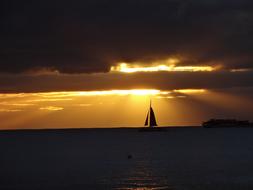 Sailboat and cloudy sunset sky