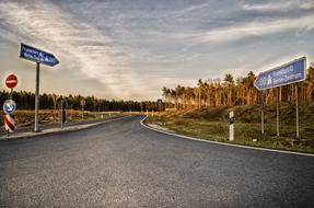 Beautiful and colorful landscape of the highway, among the plants, with the signs, at beautiful and colorful sunset, with the clouds