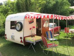 Colorful and beautiful oldtimer camping car, among the colorful plants, near the Schloss Dyck, Germany