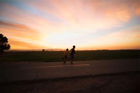 two boys running on road at Dusk