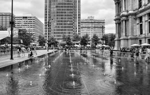 Black and white photo with the beautiful fountain near the buildings in Phildadelphia