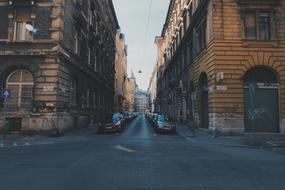 cars in a row are parked on a city street