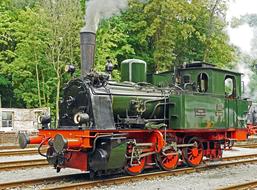 green steam locomotive on the railroad