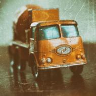 Model o the shiny, orange retro truck, in light, on the retro photo