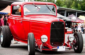 Beautiful, red, retro car with black wheels