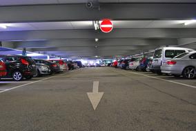 Colorful cars on the parking, in the rows, with the arrow and signs