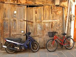 Moped and Bike parked at wooden gate