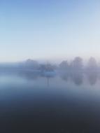 Boat on calm water at Foggy mountain