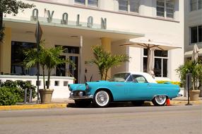 blue vintage car parked near building in miami