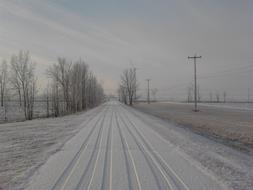 Beautiful landscape with the snowy road among the fields, in Quebec, Canada, in the winter