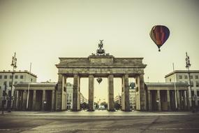 Colorful, flying hot air balloons and beautiful monument in the city