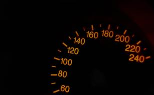 Speedometer of the vehicle, with lights, among the darkness