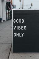 Black and white "Good Vibes Only" board sign on the street