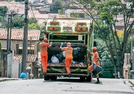 Team on the street-sweeper, on the road, among the colorful plants and buildings