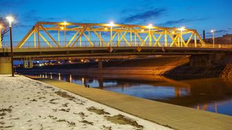 bridge with lanterns over the river at dusk