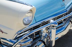Beautiful, shiny, turquoise and white, vintage car with the sign, in sunlight
