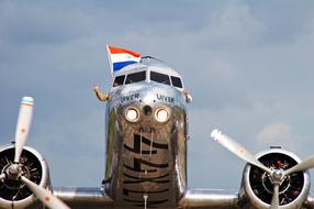 Colorful, glossy Douglas Dc 3 plane, under the blue sky with clouds