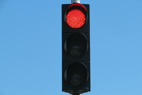 red traffic light on blue sky background