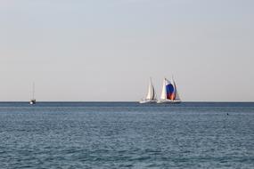 distant view of sailboats on the horizon to the sea