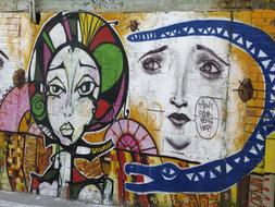graffiti in the form of female faces on the wall of the building