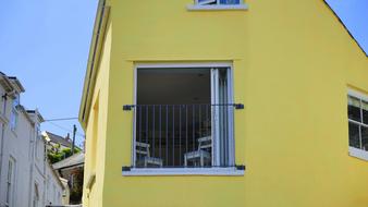 large window on the facade of the yellow house