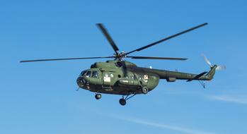 Flying Mi-8 helicopter, at the air show, under the blue sky with clouds