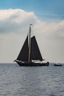 boat with black sails at sea