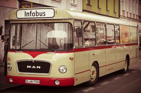 Old, retro "Man" bus near the colorful buildings on the street
