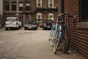 two bicycles against a brick wall