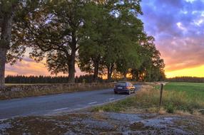 cars on a rural road at sunset in Vernamo