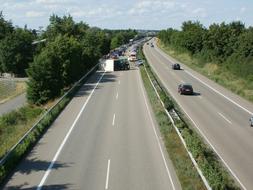 Landscape of the autobahn with cars, in sunlight, among the green plants, in Germany