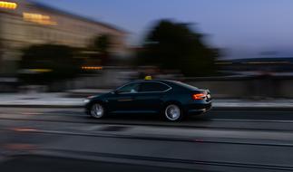 Shiny, black car on the road, in motion, in the evening