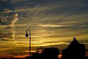 Silhouettes of the lamp and buildings in Roggwil, Switzerland, at colorful and beautiful sunset
