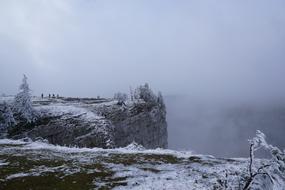 Beautiful landscape of the snowy mountains with trees, in fog, in Cruix Du Van, Switzerland