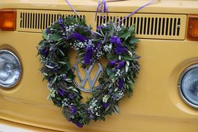 Close-up of the colorful and beautiful wreath with flowers, on the yellow "Volkswagen T1" bus
