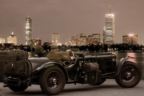 Retro photo with the people driving car, in the city with buildings and lights