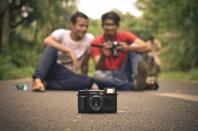 friends with analog camera on the road in blurred background