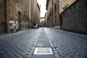 Beautiful landscape of the pavement alley with car, among the buildings